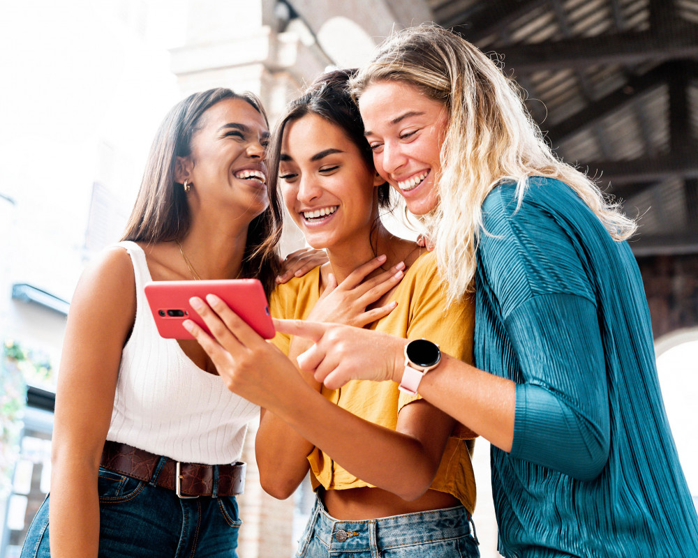 Drei Frauen schauen auf ein Smartphone