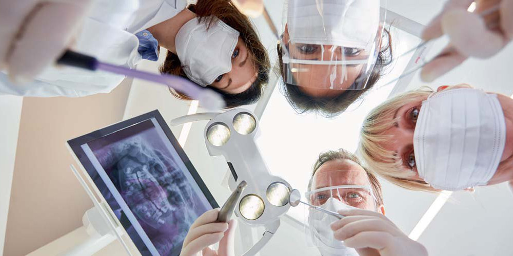 Aus Sicht des Patienten: Zahnarzt und drei Helferinnen schauen runter